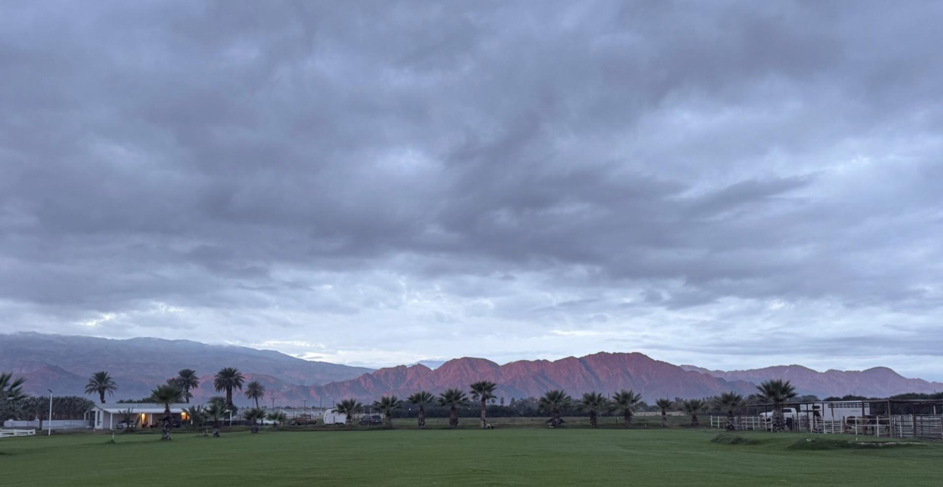 Wide view of the Mi Amor Ranch field under cloud cover with the Santa Rosa mountains behind